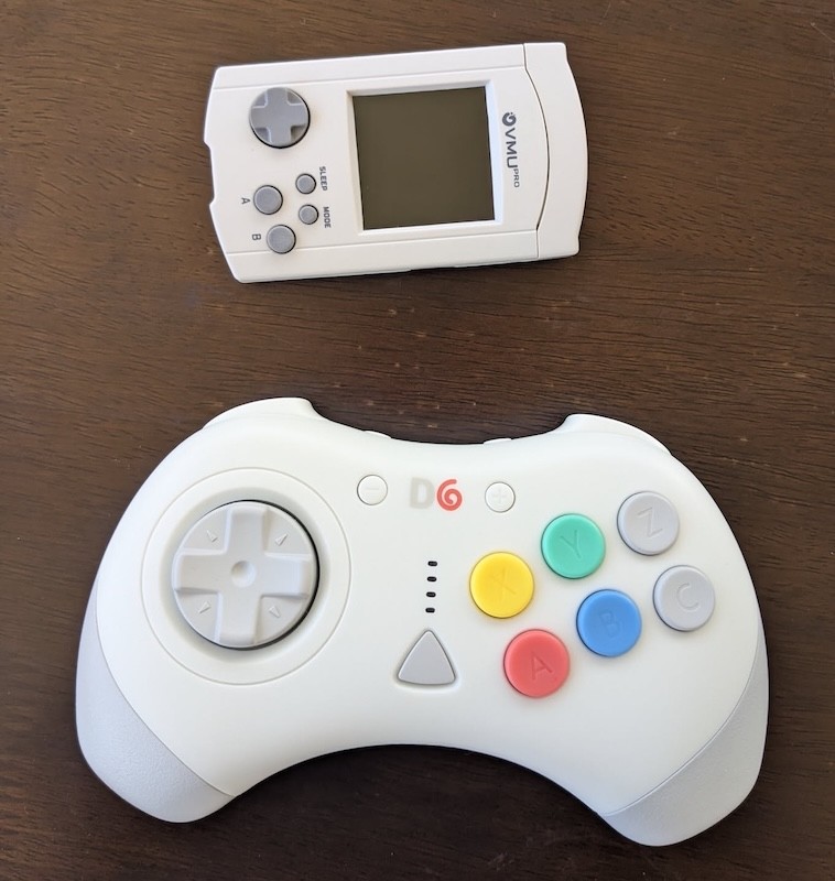 A six-button d-pad controller, matching the aesthetics of a Dreamcast controller. And an upgraded Dreamcast VMU, the 8BitMods VMUPro.